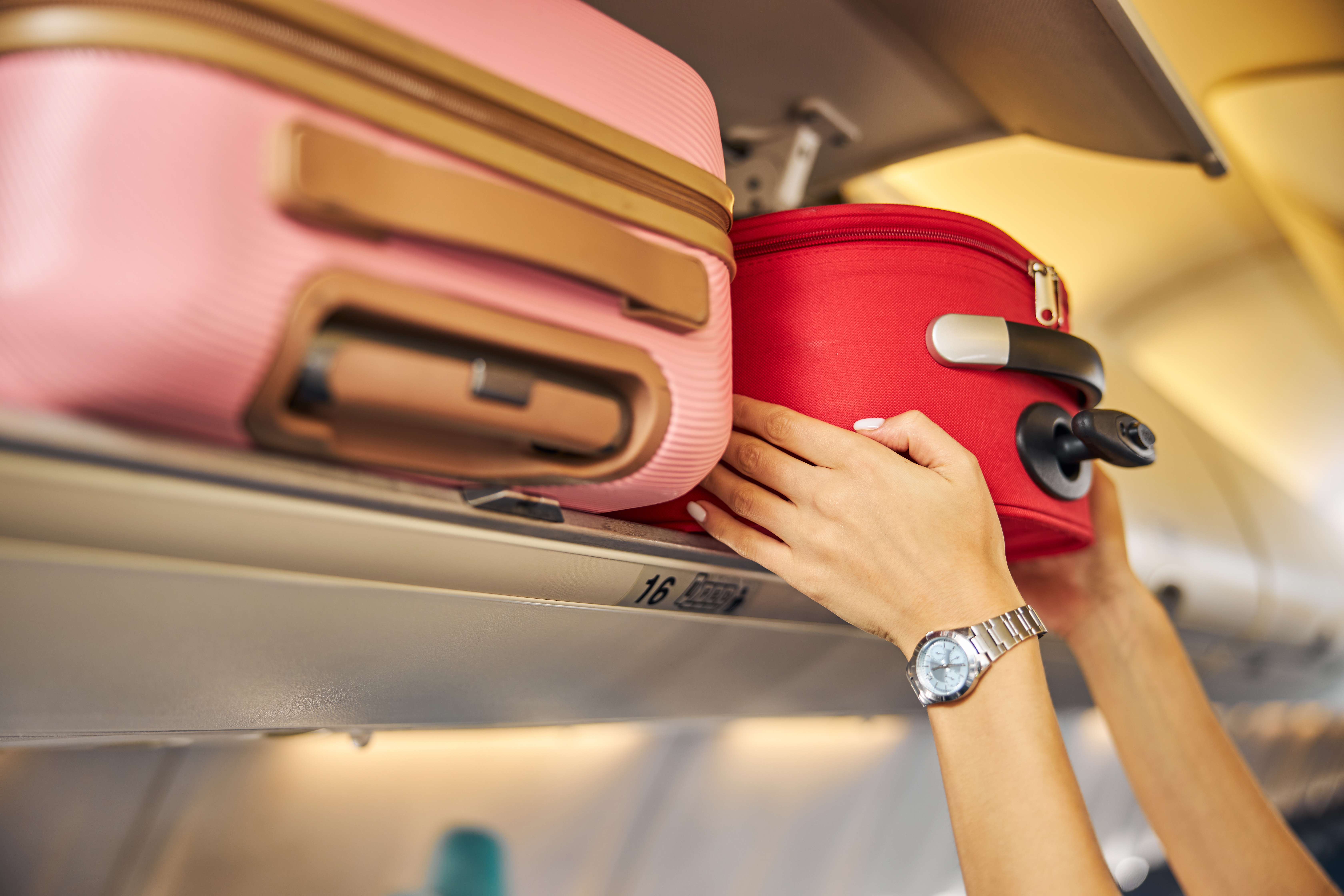 placing carry-on luggage in the airplane’s overhead shelf