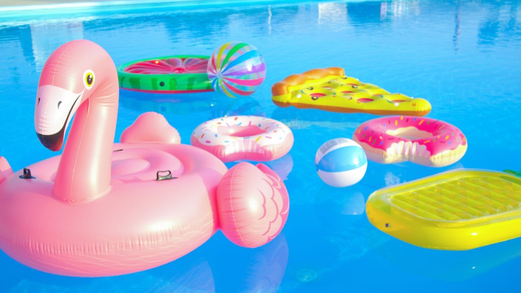 Trendy inflatable toys float around the empty pool on a sunny day
