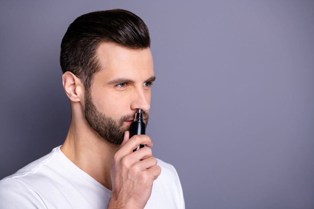 Close up side profile photo amazing he him his macho hairless process buy buyer new hand novelty ready remove nose ear hair with help comfy trimmer wear casual white t-shirt isolated grey background