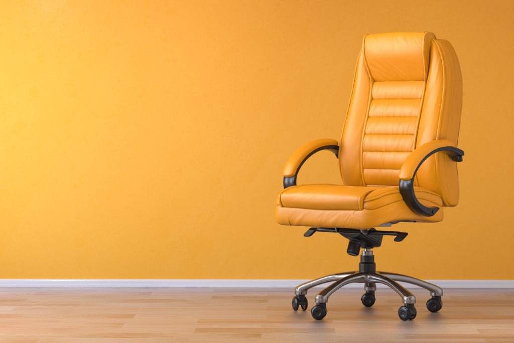 Yellow office chair in yellow interior with space for text.