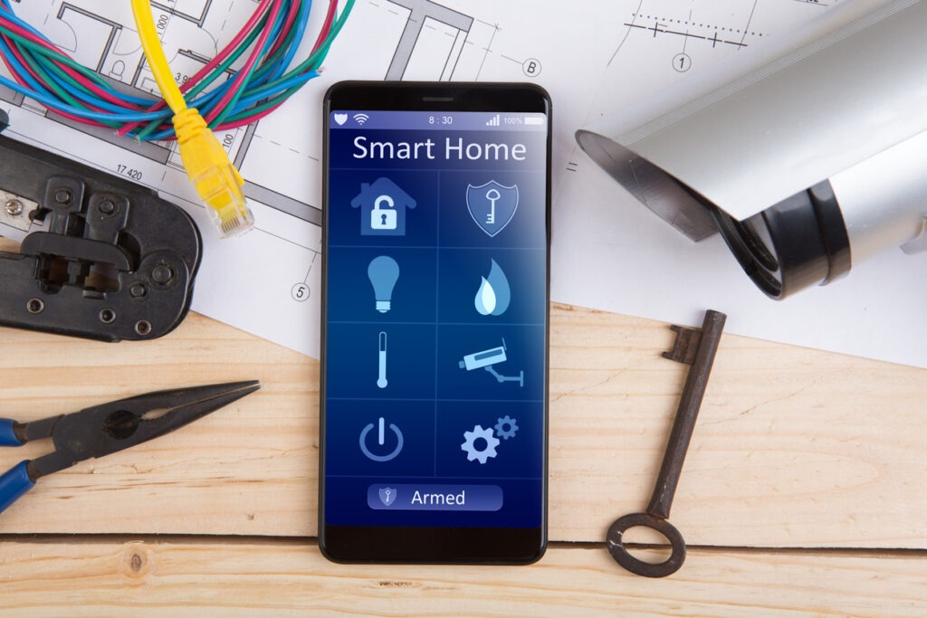 Smartphone with smart home app and surveillance CCTV camera on the desk