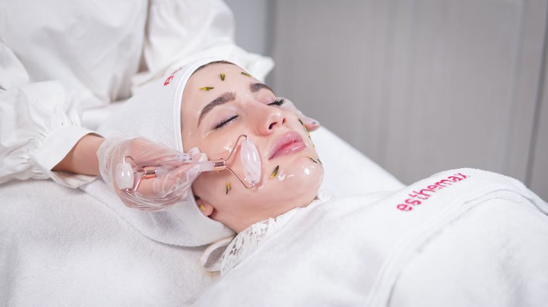 a woman receiving facial treatment with a towel on her head “esthemax”