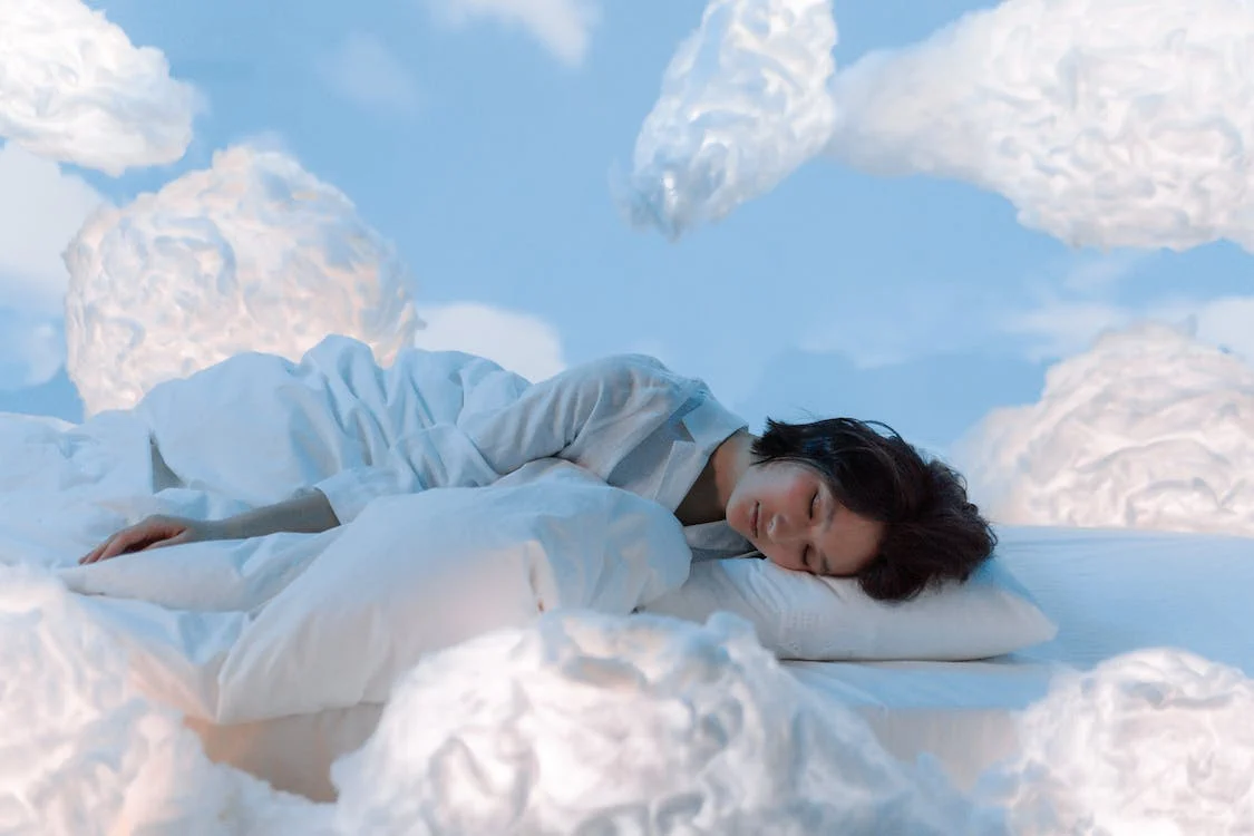 a woman sleeping next to a what looks like clouds