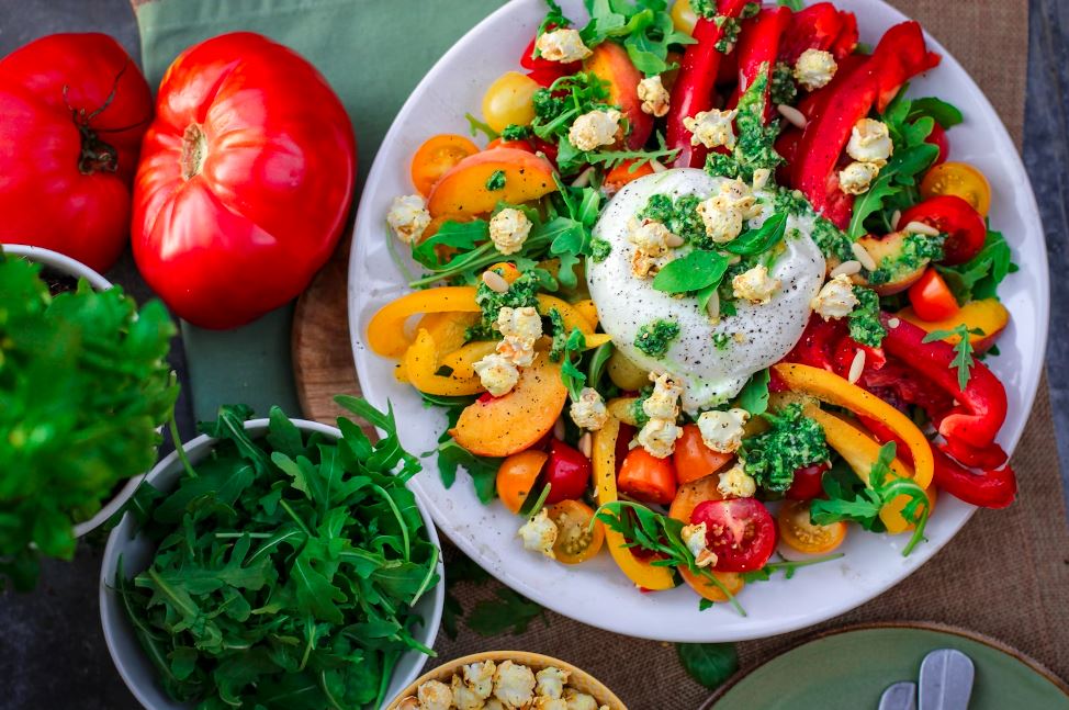 tomatoes, bell peppers, cilantros and poached eggs on a bowl