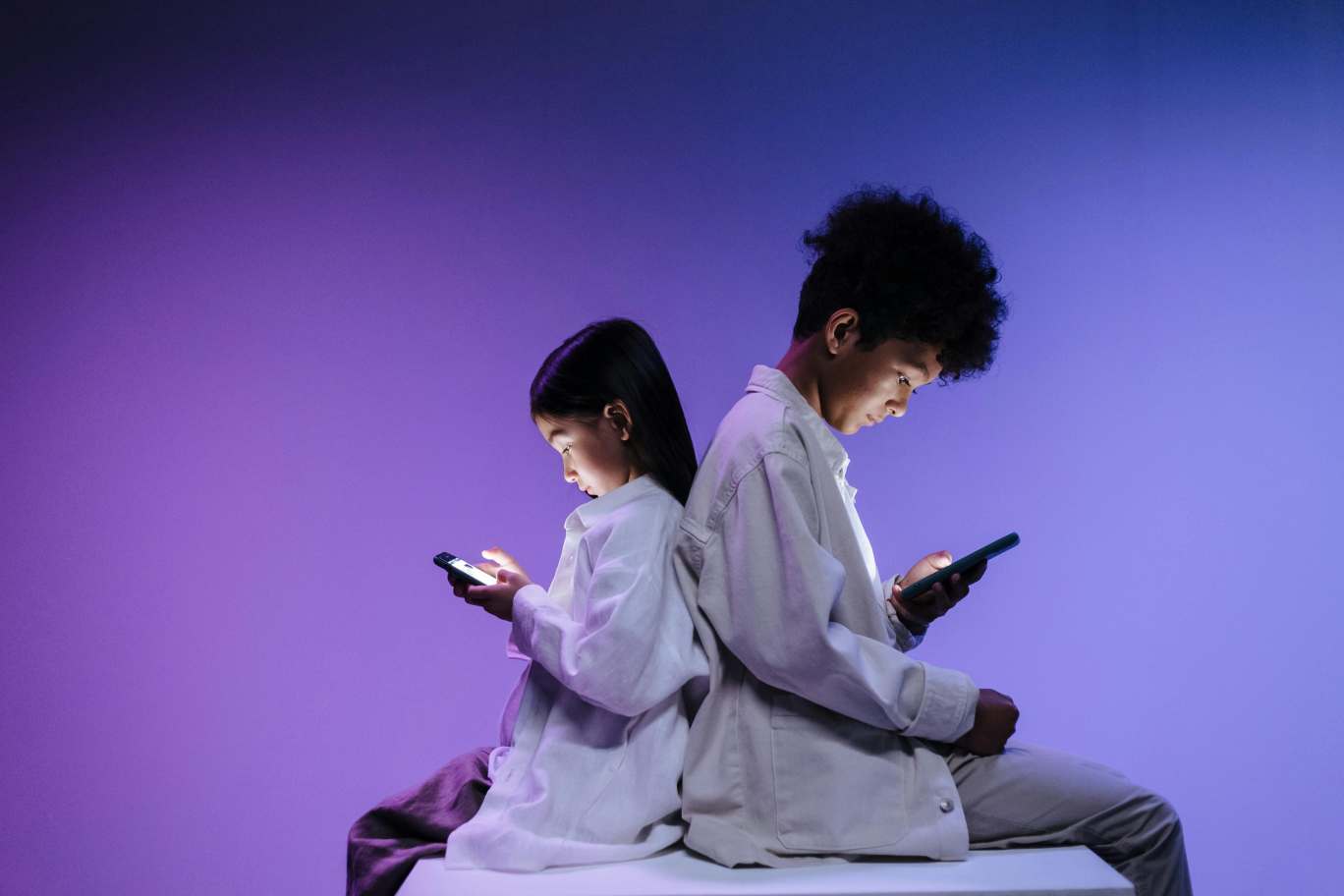 A photo of two kids using smartphones