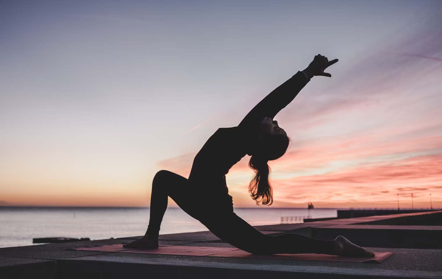 A silhouette of a woman doing yoga pose