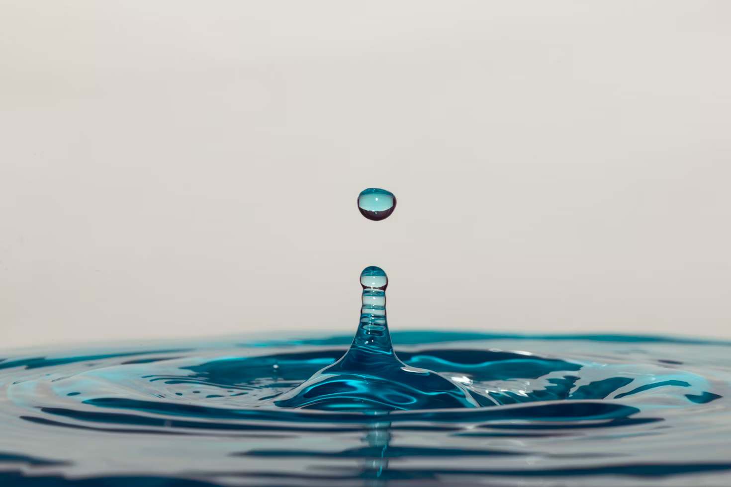 A water droplet dropping into a larger amount of water