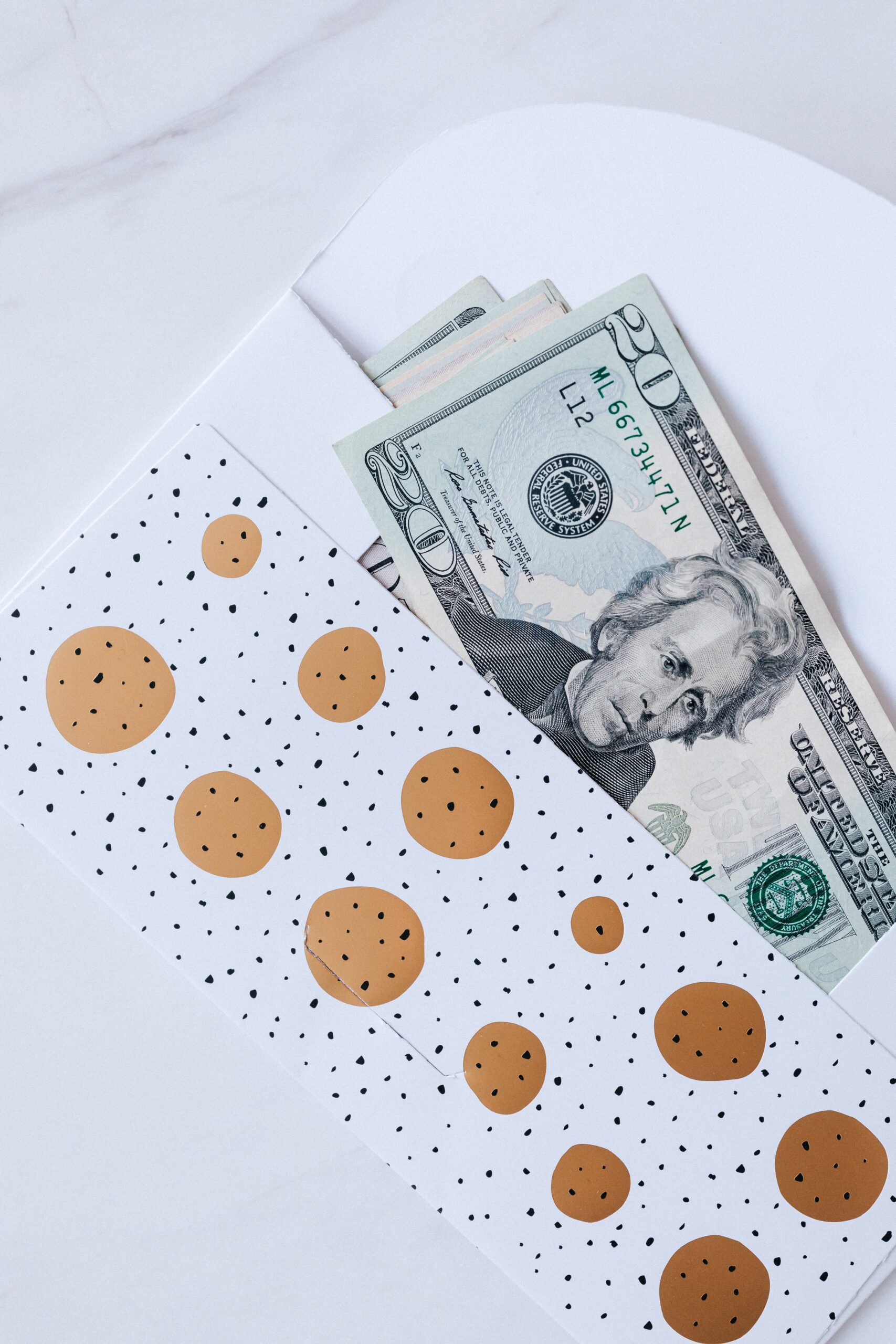 gift envelope with a heap of greenbacks on a marble table