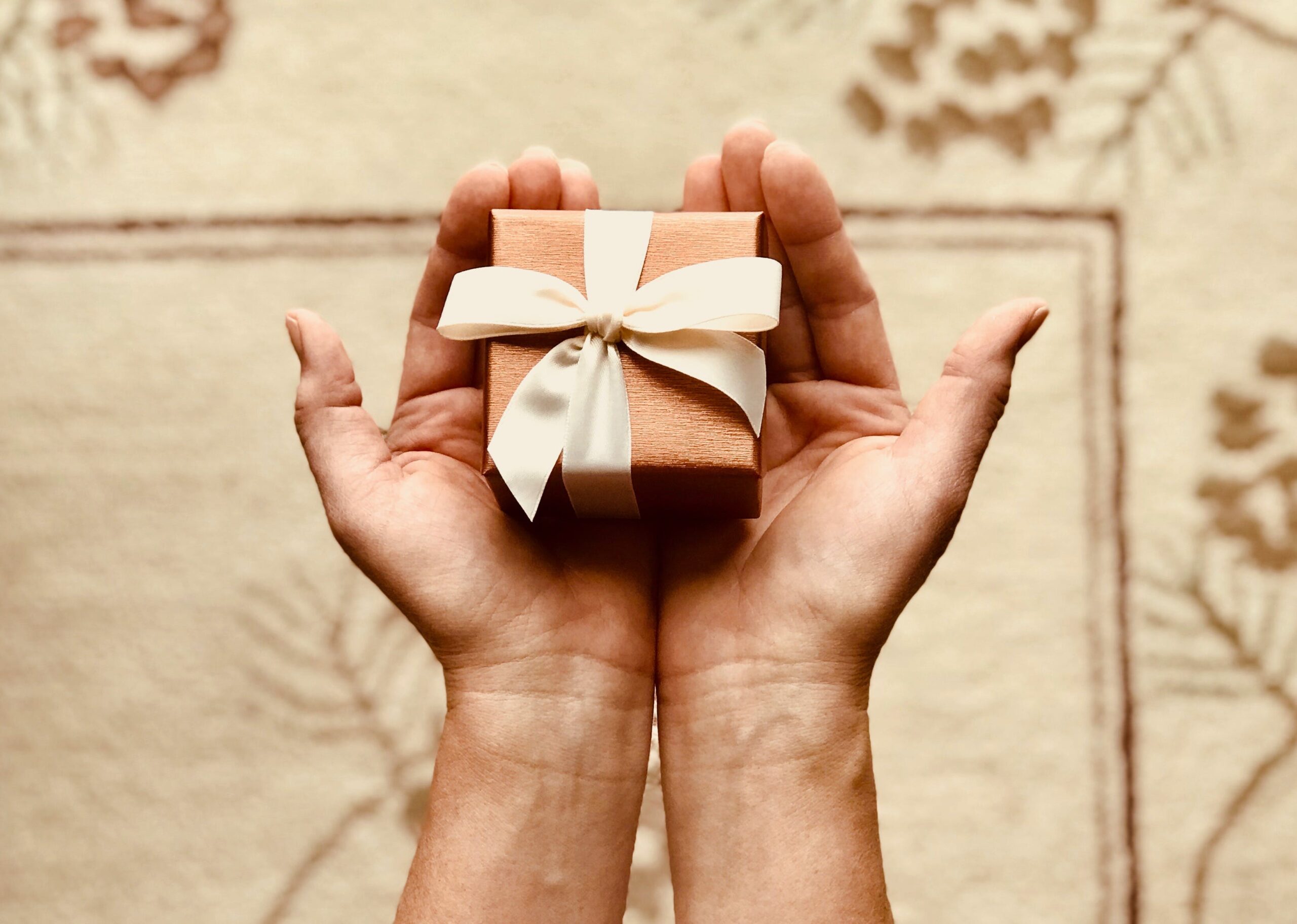 person holds brown gift box