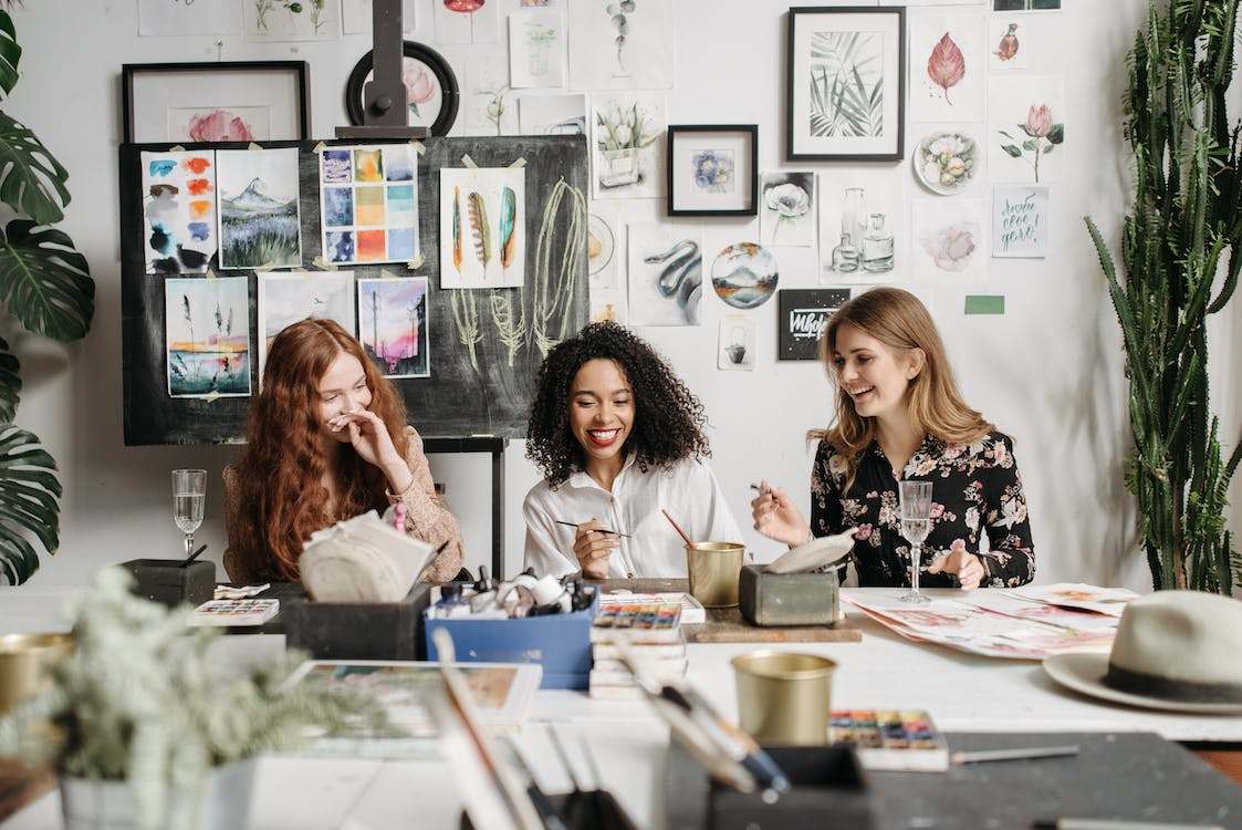 Three women laughing while painting