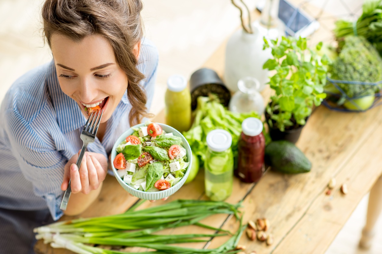 woman eating raw vegetable salad