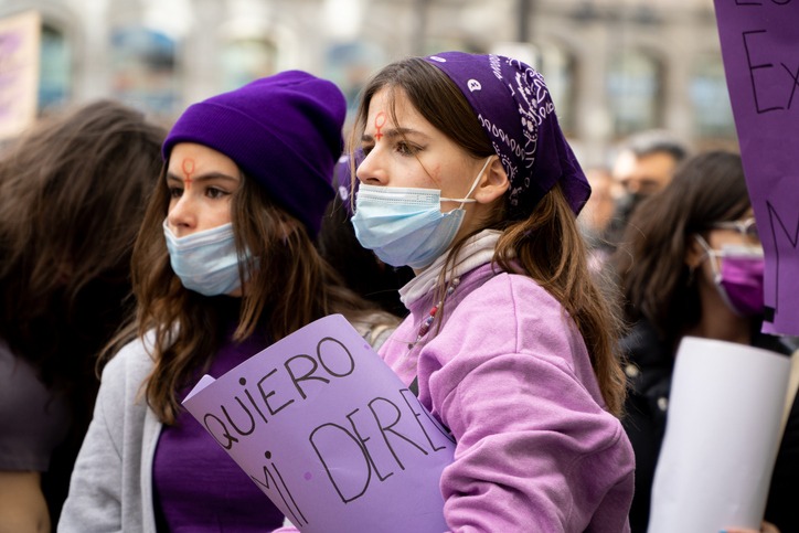 Women wearing various shades of purple protesting
