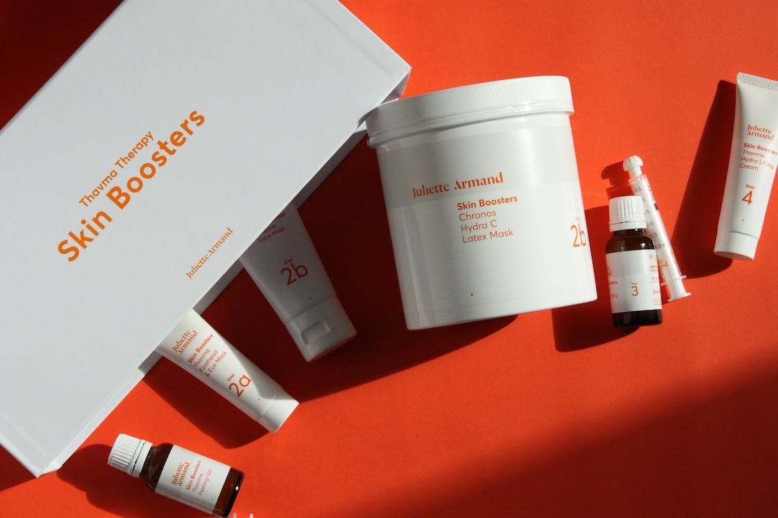 A set of skin care products on a red flat surface