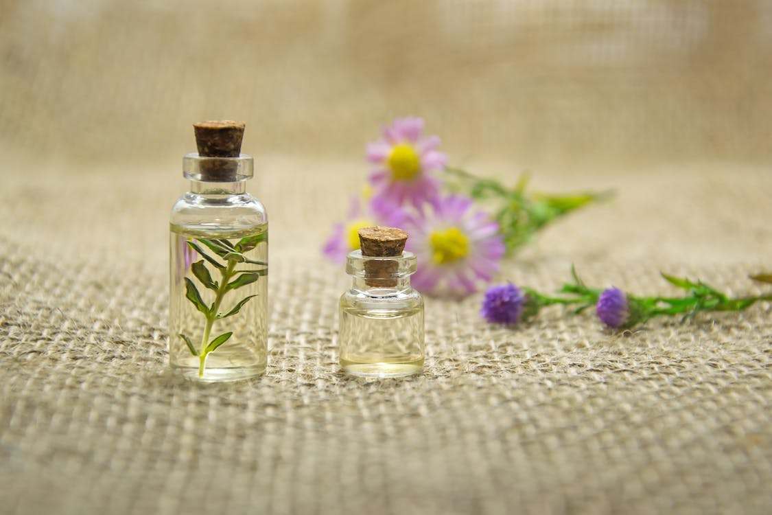 Eco-friendly perfume on the table with flowers on the background