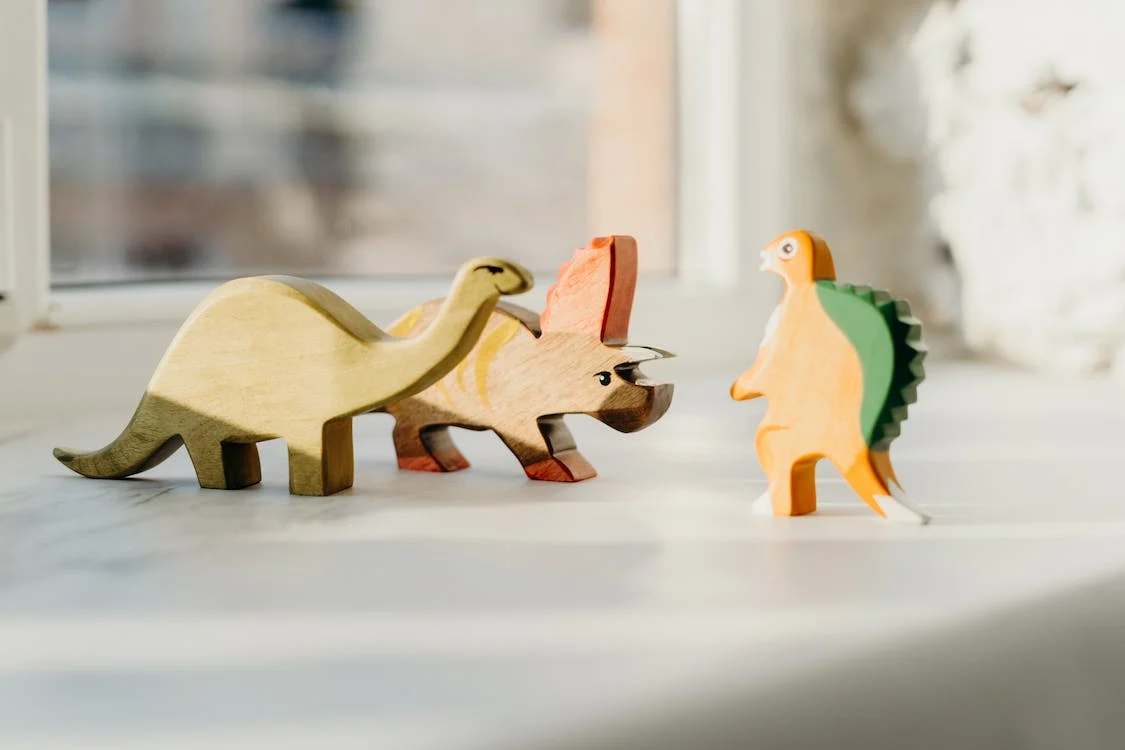 Wooden dinosaur toys on table