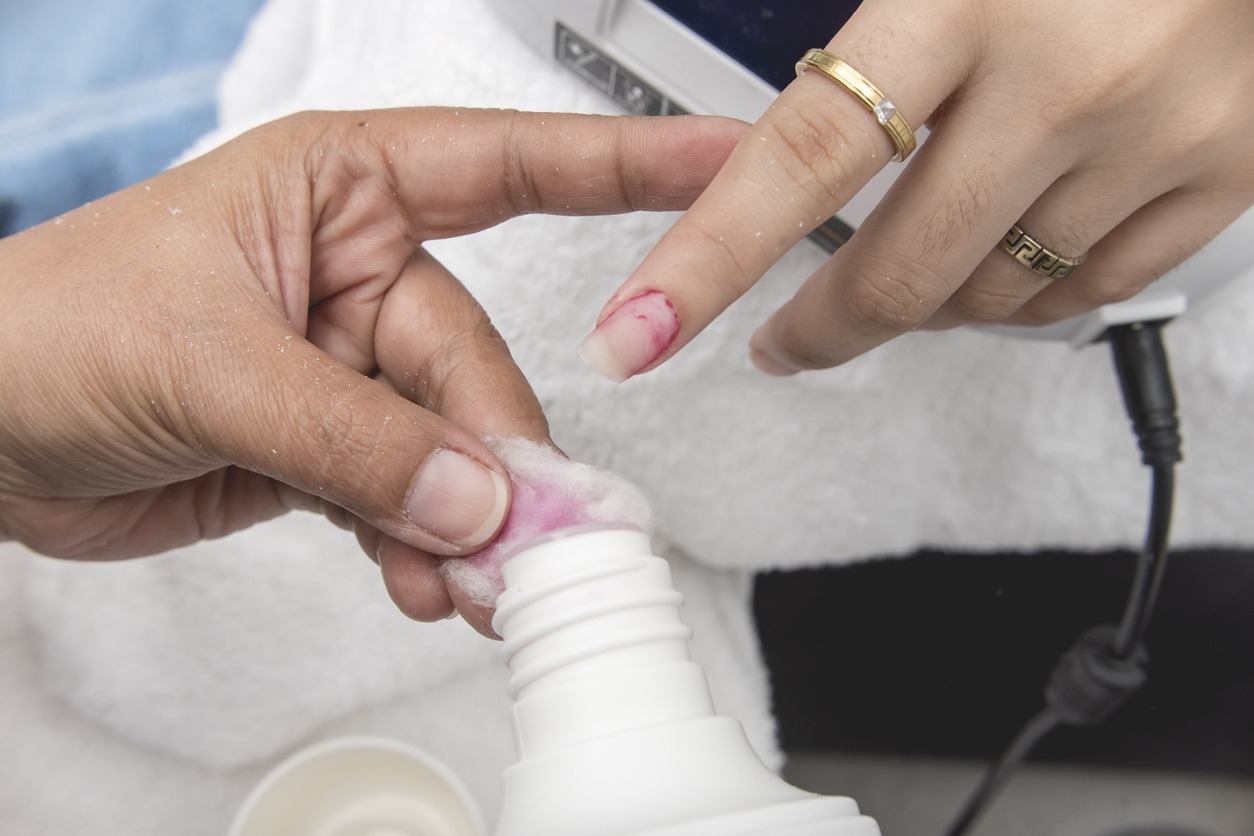 A manicurist uses a cotton bud soaked in acetone to remove leftover polish