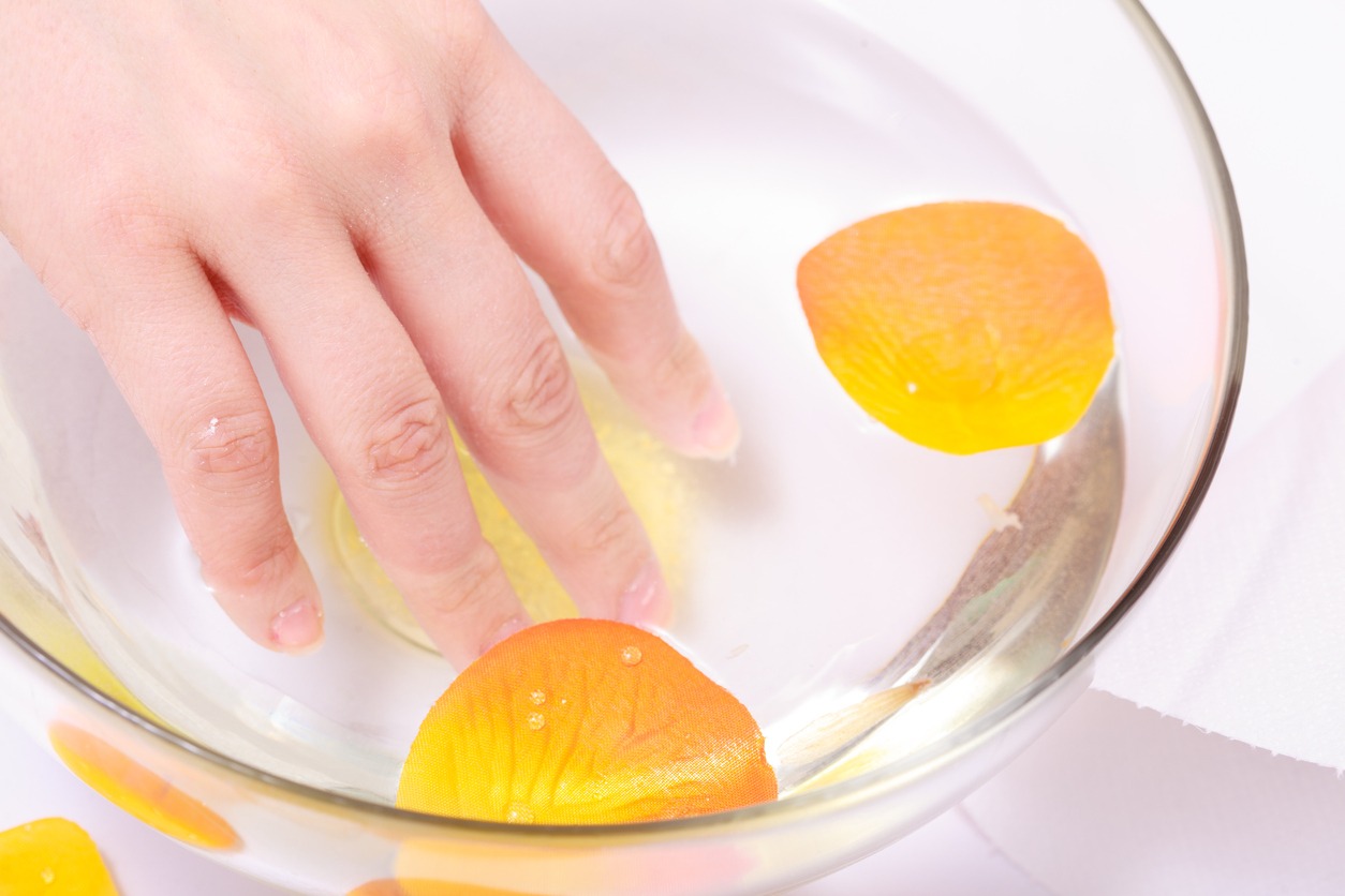 Female hand soaking glass bowl water