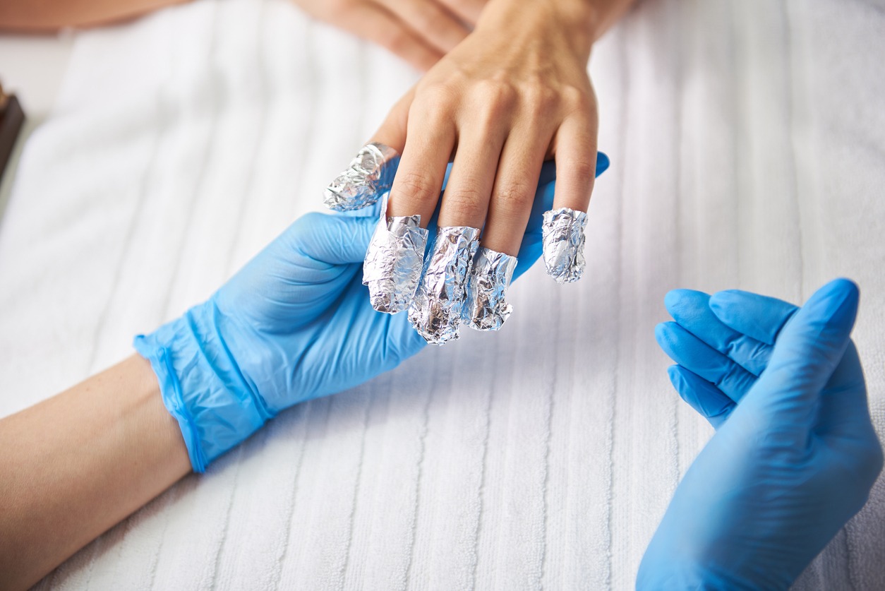 Manicurist checking lady fingers with strips of foil
